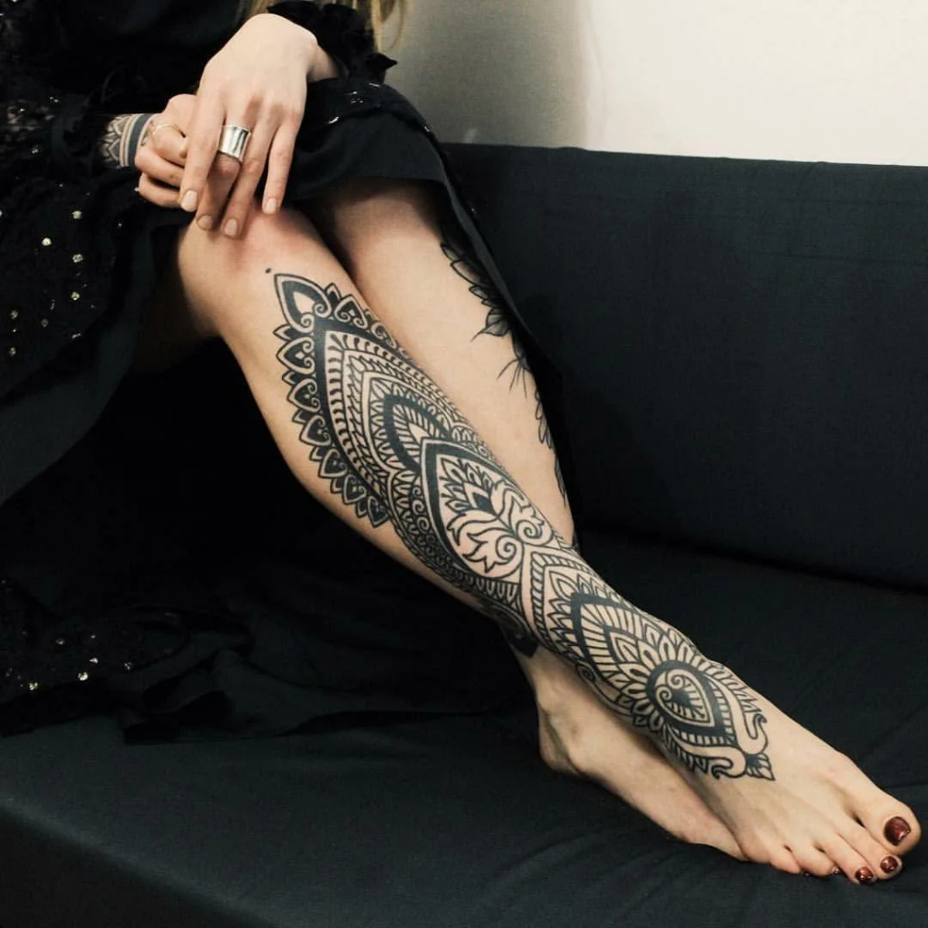 Trendy tattoo concepts for women's legs, highlighting modern and chic artistic elements